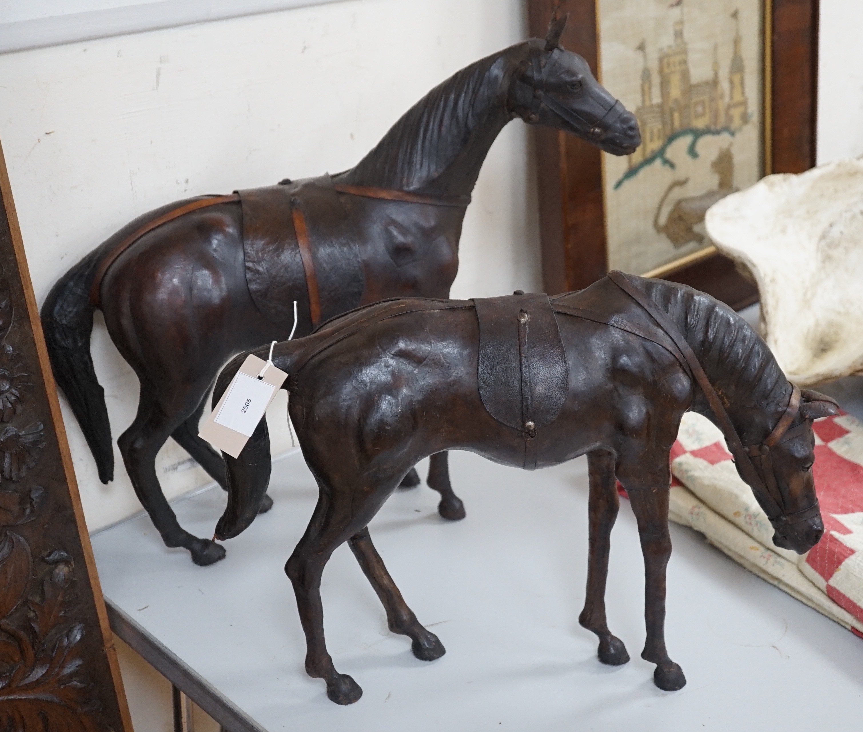 Two finely modelled horses made from brown leather, tallest 49 cms high